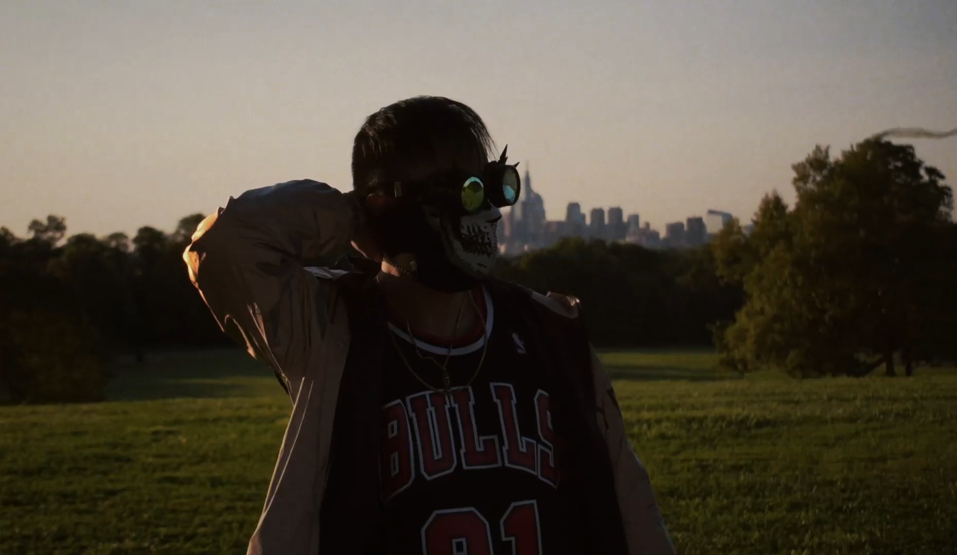 Portrait of a person in green goggles with a distant city skyline